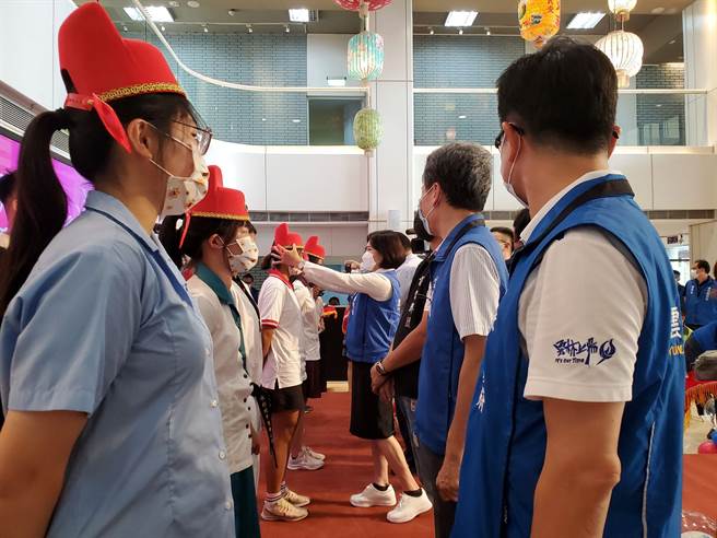 云林县府今年首次发放全县高三学生成年礼，22日记者会上，张丽善（中伸手者）为各校的代表学生象徵性「加冠」祝福。（周丽兰摄）