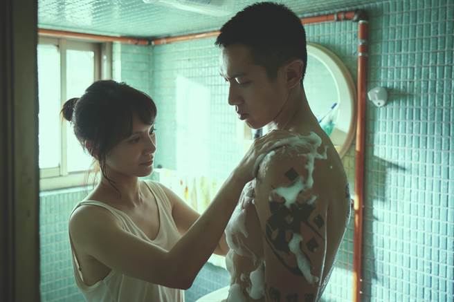 李心洁（左）在《鱷鱼》中帮受伤的柯震东洗澡。（台北双喜电影提供）
