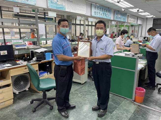 金湖分局長林炎巨贈牌給金門山外郵局行員黃欽銘，感謝在第一線把關阻詐。（警方提供）
