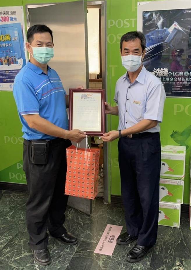 金湖分局長林炎巨贈牌給金門沙美郵局經理吳信立，感謝在第一線把關阻詐。（警方提供）