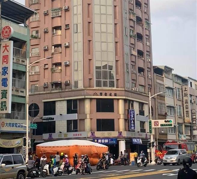 長髮女子站在三民區九如路和哈爾濱街口的1棟大樓10樓高處窗台，試圖輕生，消防員在地面鋪氣墊，並升雲梯車救援，所幸警方將她一把拉進屋。（翻攝臉書爆料公社／石秀華高雄傳真）
