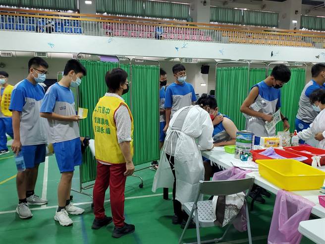 斗六国中施打疫苗井然有序，学生们拿着黄卡逐一接种。（周丽兰摄）
