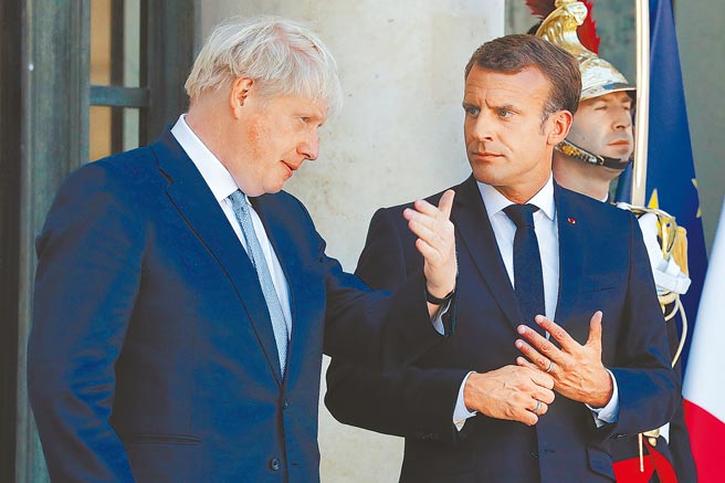 對巴黎因潛艦風波發怒，英國首相強森昨（22）日特別參雜法文請求法國「自我克制」，還要求法國人「饒了我吧」。圖為強森（左）與法總統馬克洪（右）過往會面的畫面。（新華社）
