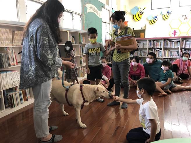 伴讀書僮，不僅吸睛，更讓不少原本躁動的孩童，變安靜了。(高雄市動保處提供／林雅惠傳真)