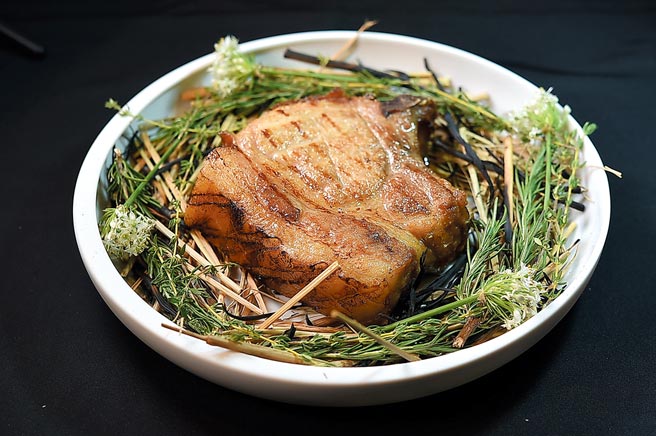 〈南投放牧猪〉是以黑毛猪与肌肉发达的杜洛克猪配种饲育，主厨取脂肪较多的里肌部位先炭烤、再烟熏，然后分切呈盘。图／姚舜