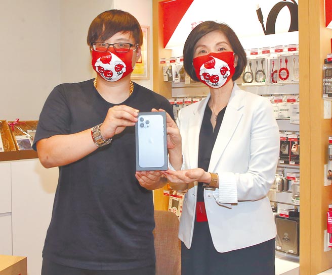 远传电信总经理井琪（右）与排队15小时、抢得头香的刘先生合影，他选择搭配「远传心5G」月付1399资费24个月，花2万3300元带走原价3万6900元的iPhone 13 Pro Max 128G天峰蓝新机。（赵双杰摄）