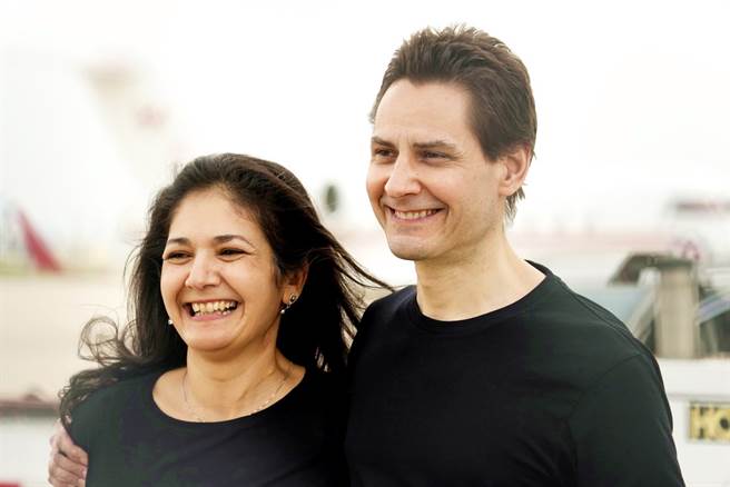 加拿大前外交官康明凯（Michael Kovrig，图右）25日返抵多伦多与妻子纳吉布拉（图左）团聚。（图／美联社）