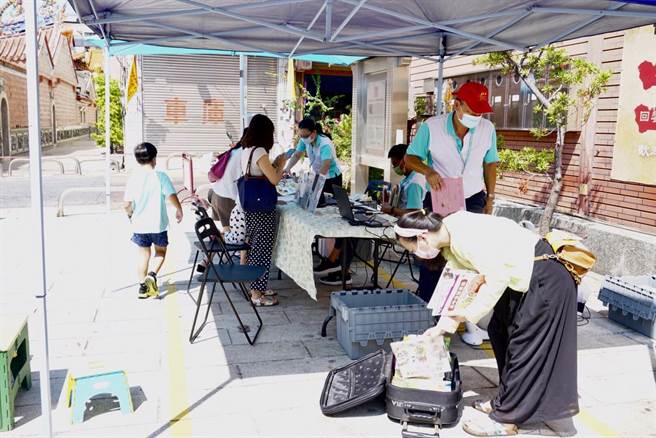 台中市立图书馆的行动图书车26日重返万和宫庙埕，受理借书及办证服务，337年歷史的万和宫香烟裊绕也飘书香。（卢金足摄）