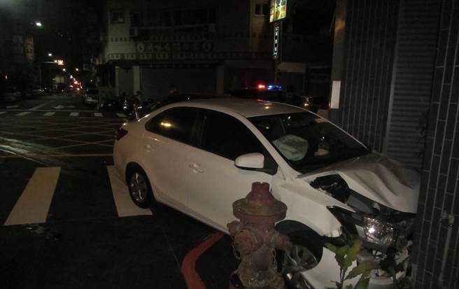 白色轎車與鐵灰色轎車發生碰撞後又轉向、衝撞路旁民宅，車頭毀損。(民眾提供／林欣儀台中傳真)