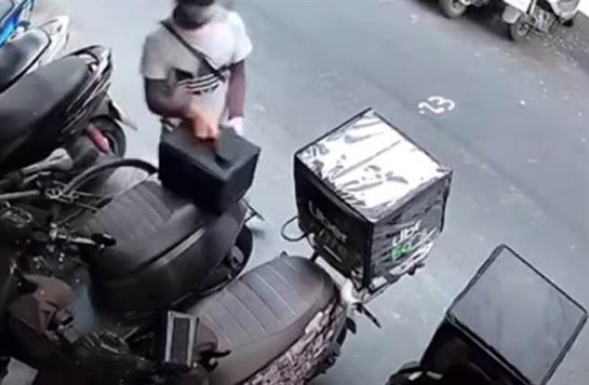 影片显示一名ubereats外送员在84秒内连续拿走两辆机车上的2样装备 。（截自YouTube影片）