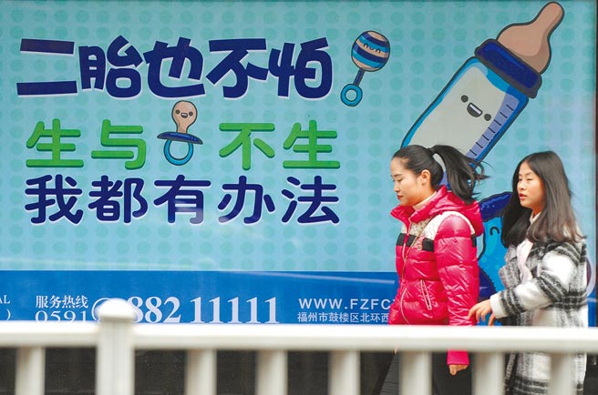 為改善人口快速高齡化等問題，今年8月20日，大陸全國人大已修改人口與計畫生育法，將三孩政策和配套措施予以立法通過。為進一步完善鼓勵生育政策法規，大陸國務院26日公告廢止包含《社會撫養費徵收管理辦法》等3部行政法規，並從公告日起實施。圖為民眾經過二胎廣告。（中新社）