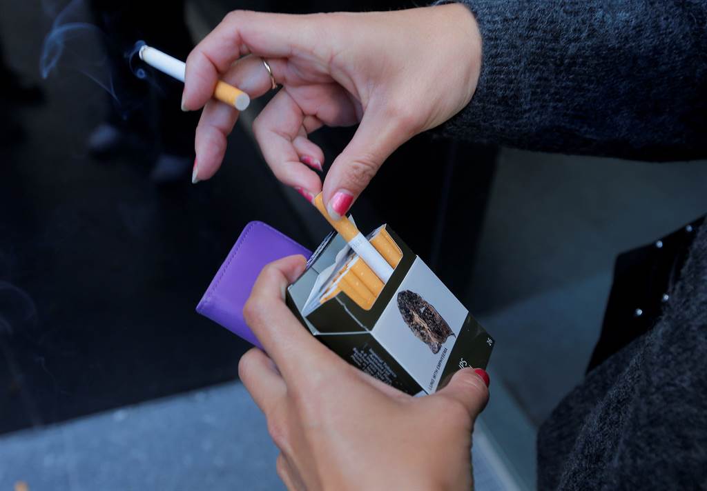 一名抽菸的人拿着包菸。（图／路透）(photo:ChinaTimes)