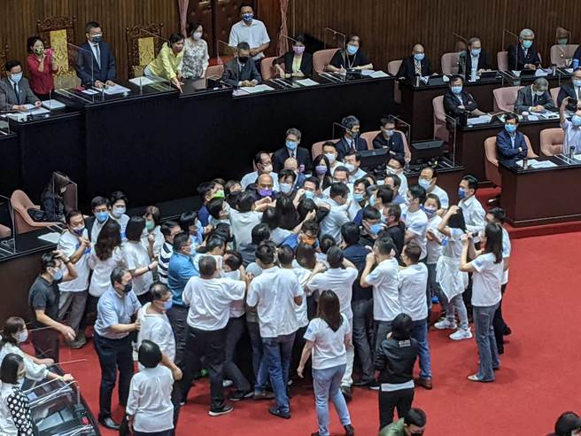 行政院长苏贞昌在绿委筑起人墙的保护下，在推挤中狼狈走到发言台完成52字的施政报告。(朱真楷摄)