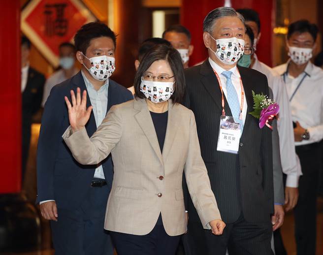 蔡英文总统（中）28日在侨委会副委员长吕元荣（右）陪同下，出席世界台商会年会暨理监事联席会议开幕典礼，她离去时向媒体挥手致意。（范扬光摄）