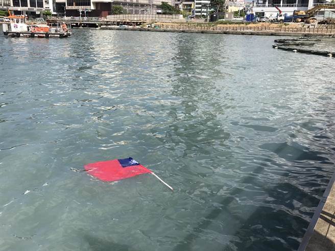 插在栏杆上的国旗断裂数根，有的漂浮在海面上。（陈彩玲摄）