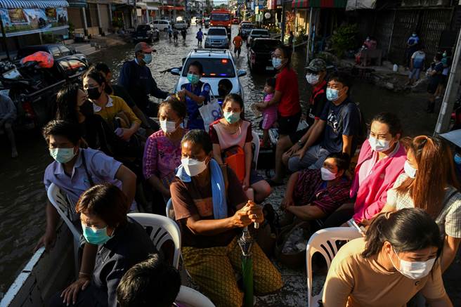 泰國人民乘坐卡車試圖穿越過該國Chaiyaphum省一條被淹沒的道路。（圖／路透）