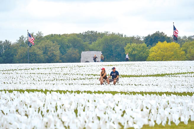 新冠疫情导致2020年人类预期寿命出现二次世界大战以来最大降幅，其中又以美国男性的预期寿命降幅最大。图为超过66万白色旗帜摆放在美国华盛顿纪念碑，悼念美国超过66万名新冠逝者。（新华社）