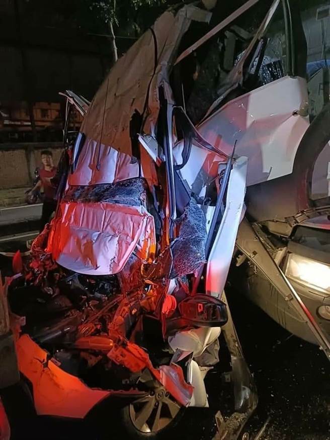 高雄市小港区沿海二路29日晚间发生严重车祸，疑似为一辆自小客车被货柜车、联结车夹撞，自小客车车体经严重挤压已完全变形。（民眾提供）