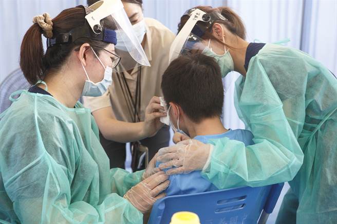 一名国中生在护理师、老师安抚下，完成BNT疫苗接种。（张铠乙摄）