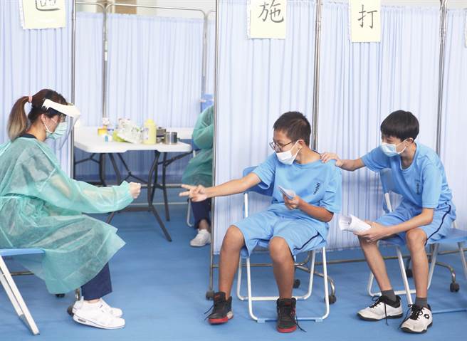 台北市国中生30日开始到10月6日施打BNT疫苗，一名护理师为放松学生打针紧张的情绪，在施打站门前与学生玩起剪刀石头布。（张铠乙摄）