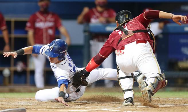 中华职棒富邦与乐天之战，富邦申皓玮（左）在本垒被乐天林泓育（右）触杀出局。（季志翔摄）