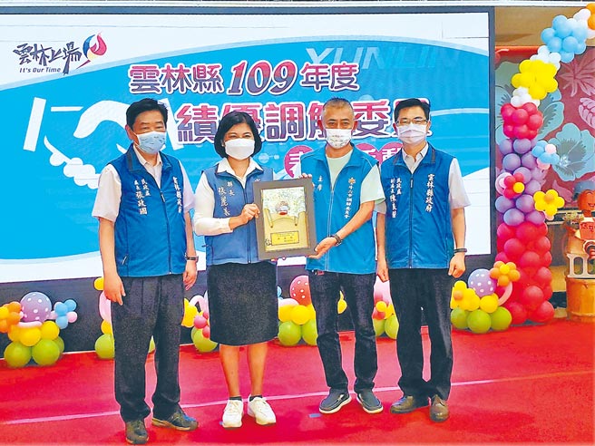 云林县府29日由县长张丽善（左二）颁奖表扬绩优调解委员，这是洪启文10年来第一次缺席，县府特地为他制作特别奖，由好友同事、斗六市调解委员会主席陈天星（右二）代领。（周丽兰摄）