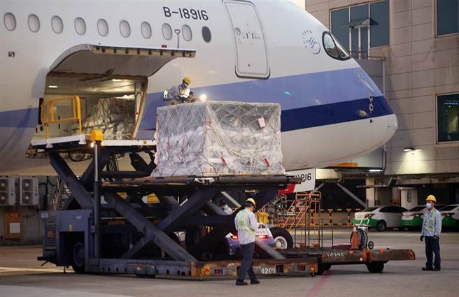 第2批客制化标籤BNT疫苗1日清晨运抵桃园机场，地勤人员将装载疫苗的货柜从机舱卸下。（范扬光摄）