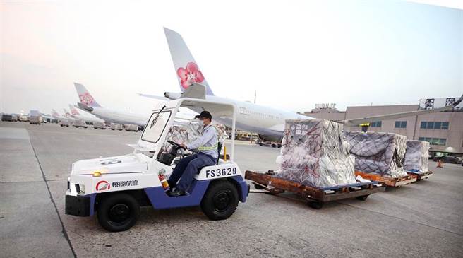 地勤人员将装载疫苗的货柜运往货运仓储。（范扬光摄）