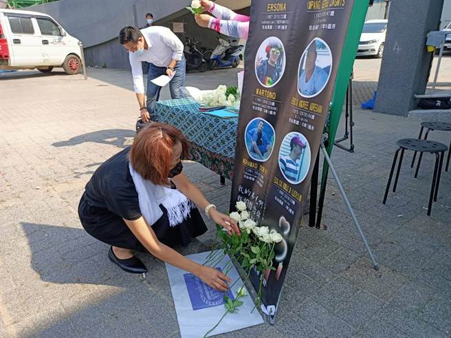 參與追思會的人員依序在罹難的外籍漁工照片前獻花表達哀思。（胡健森攝）