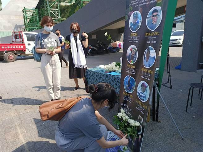  參與追思會的人員依序在罹難的外籍漁工照片前獻花表達哀思。（胡健森攝）