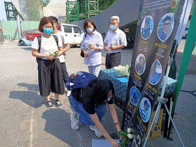  參與追思會的人員依序在罹難的外籍漁工照片前獻花表達哀思。（胡健森攝）