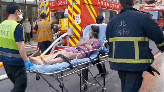 新北市泰山明志路一栋公寓2日清晨发生火警，警消获报到场后布水线救出5人，其中3人ohca（到院前死亡），3人经抢救后皆宣告不治，详细起火原因待调查；救护人员按压伤者胸口抢救，火灾现场聚集不少关心民眾。（郭吉铨摄）