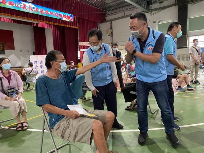 杨镇浯县长访视大型接种站作业，在金寧中小学体育馆巧遇老县长陈水在，开心的向他拱手致意。（县府提供）