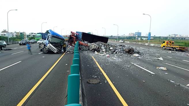 國道1號南向331.5公里仁德戰備跑道路段，一部半聯結車之曳引車頭左前輪爆胎失控衝向中央分隔島，並翻覆，道路散落其所載運的廢五金。（翻攝國道公路警察局）