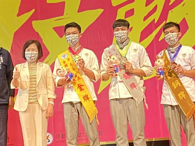 西餐烹饪竞赛拿下前3名的选手和劳动部长许铭春合影。（石秀华摄）