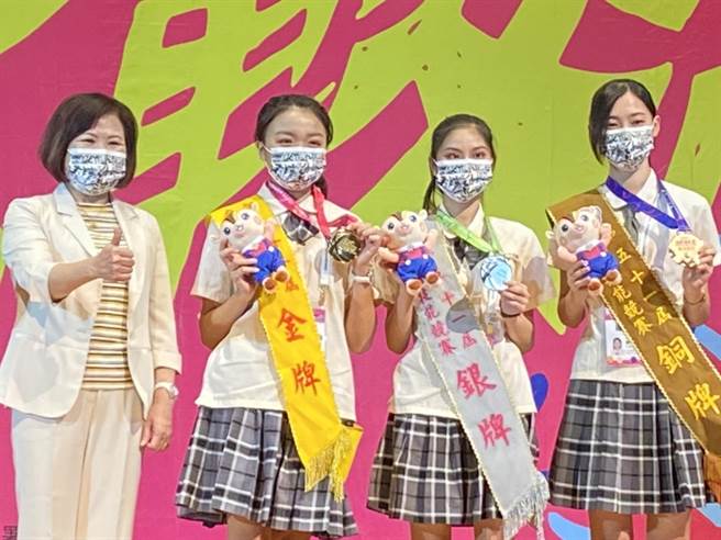 拿下旅馆接待前3名的选手和颁奖的劳动部长许铭春合影。（石秀华摄）