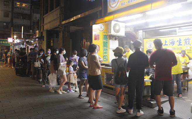 國內新冠肺炎疫情漸趨穩定，中央流行疫情指揮中心預計3日將公布新措施，可望鬆綁郊區野外戴口罩規定，指揮官陳時中透露，夜市邊走邊吃還是持續禁止的，圖為許多民眾2日在士林夜市著名的生煎包店外排隊等候。（張鎧乙攝）