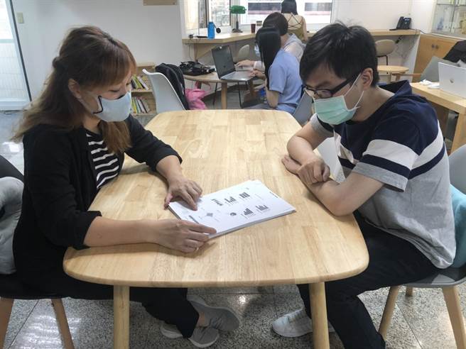諮詢師與青年面對面諮詢，說明診斷測驗結果。（台中市政府提供）