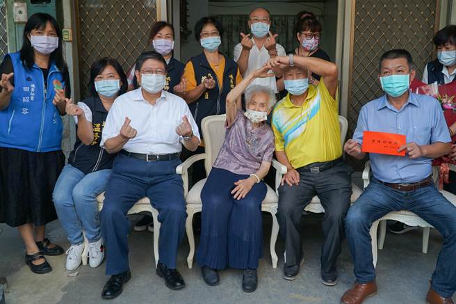 峨眉乡刘焕增、刘温香夫妻相守超过一甲子，与县长杨文科（左三）合影时还举手比出爱心的姿势。（罗浚滨摄）