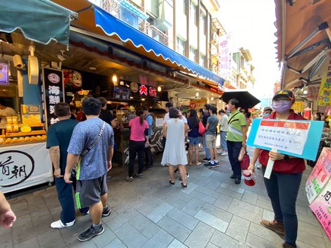 金包里老街中午湧現人潮，區公所派員在場防疫宣導。（金山區公所提供）