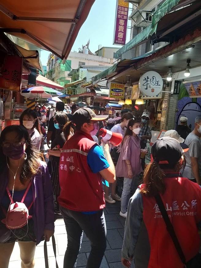 金包里老街中午湧現人潮，區公所派員在場防疫宣導。（金山區公所提供）