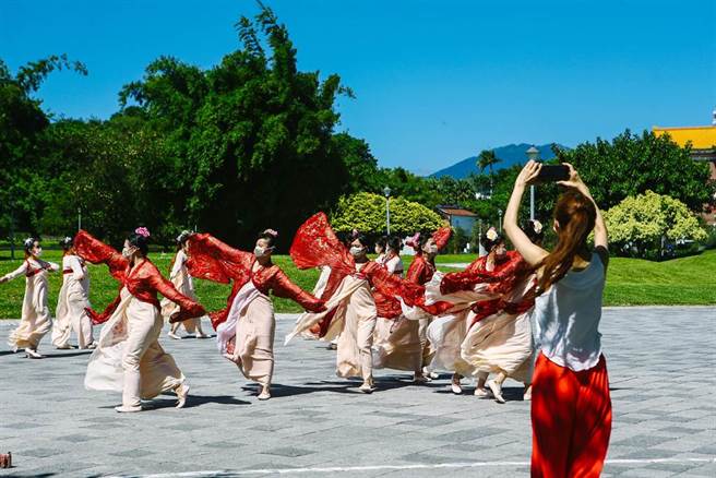 假日花博公园，有一群表演者穿着长袖舞衣，戴着口罩在空旷处练习。中央流行疫情指挥中心3日公布国内无新增死亡与本土案例，指挥官陈时中表示，目前疫情维持稳定，针对现行户外戴口罩的政策进行调整，位于空旷区域时可以免戴口罩。（邓博仁摄）