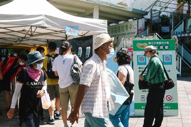 假日花博公园内，有民眾戴着口罩逛花博农民市集。中央流行疫情指挥中心3日公布国内无新增死亡与本土案例，指挥官陈时中表示，目前疫情维持稳定，针对现行户外戴口罩的政策进行调整，位于空旷区域时可以免戴口罩。（邓博仁摄）