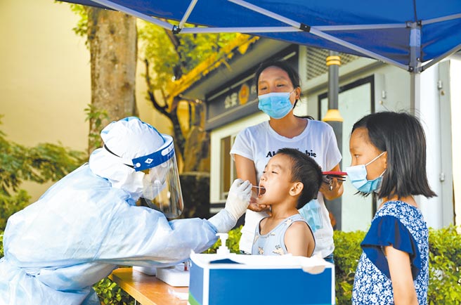 9月25日到10月1日，云南累计报告69名境外输入确诊病例，其中60例是投案自首。图为今年7月云南瑞丽居民接受核酸检测。（新华社）