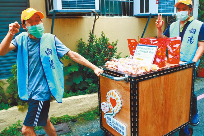 小威（右）與小坤（左）是屏東縣向陽啟能協會的金牌銷售員，從據點到推車都是最佳拍檔，他們喜歡與人接觸也因沿街叫賣而自信心大增。（謝佳潾攝）