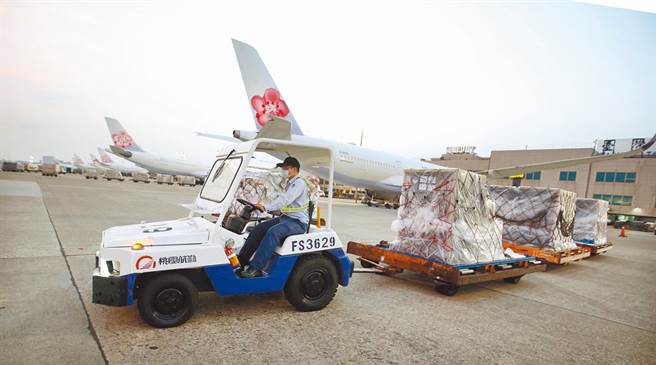 第3批客制化标籤BNT于4日抵台。图为第2批客制化标籤BNT疫苗1日清晨运抵桃园机场，地勤人员将装载疫苗的货柜运往货运仓储。（范扬光摄）