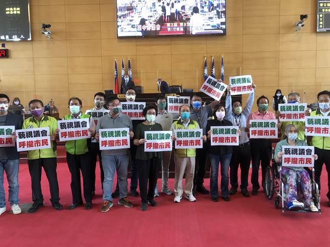 民進黨市議員每人手持一張「藐視議會、呼攏市民」衝向主席台。（陳世宗攝）
