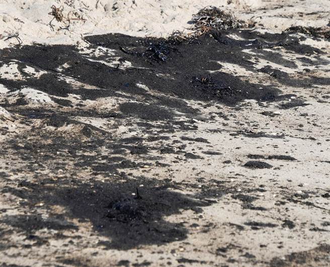 美國南加州外海油管漏油，原油已經飄向岸邊，在沙灘上形成一點一點的黑色油漬。（圖／路透社）