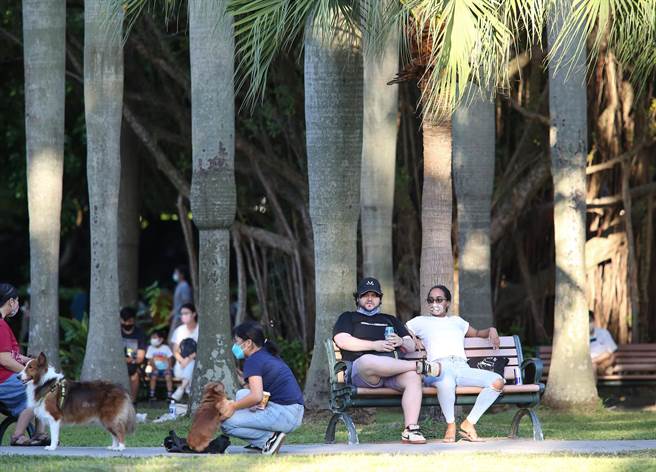 国内新冠疫情趋缓，中央流行疫情指挥中心公布，对户外空旷、人流较少的地方，适度松绑戴口罩政策，图为有些民眾戴口罩，也有把口罩放到下巴在公园乘凉。（陈俊吉摄）
