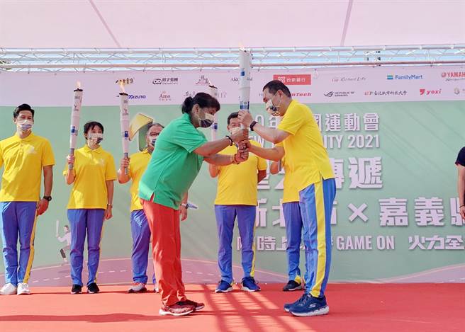 110年全国运动会圣火今抵达嘉义县故宫南院，由跑遍全台马拉松的「超级妈妈」陈嘉龄担任故事火炬手，在新北市长侯友宜，嘉义县长翁章梁传递、见证下，交棒给嘉义县金牌角力选手侯旻汶。（吕妍庭摄）